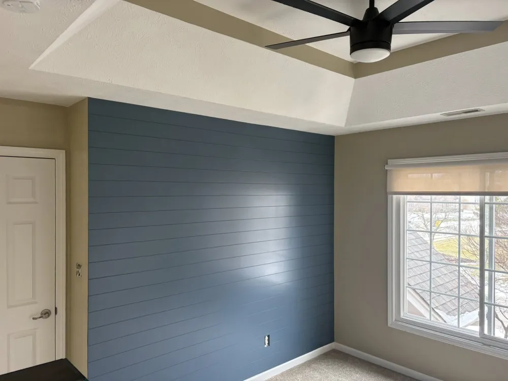 Navy blue shiplap accent wall in bedroom — shiplap boards painted in rich navy with tray ceiling